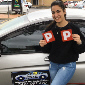 Female Student holding up P plates after passing driving assessments